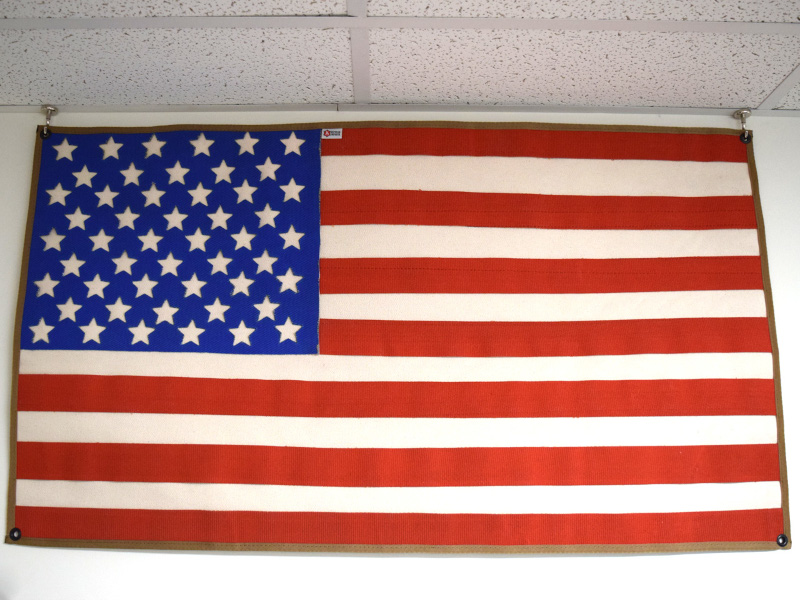 Open j-hook magnets hanging american flag from a suspended ceiling