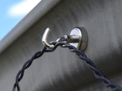 Hook magnet hanging on aluminum gutter with ring magnet on inside supporting it