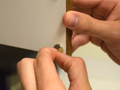 Adhesive magnet on inside of kitchen cabinet for a clean and easy install