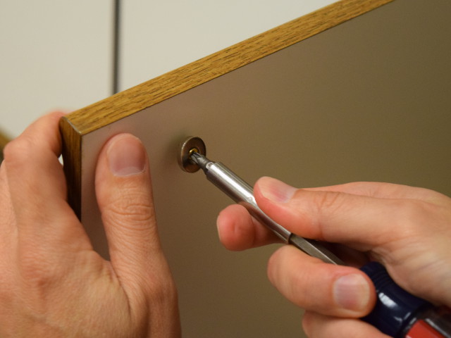 Screwing magnet into back of cabinet door