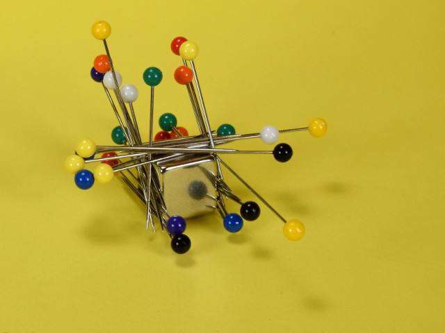 Pins stuck all over a magnet
