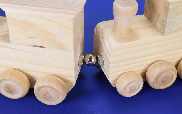 Train coupling with magnets and a steel ball
