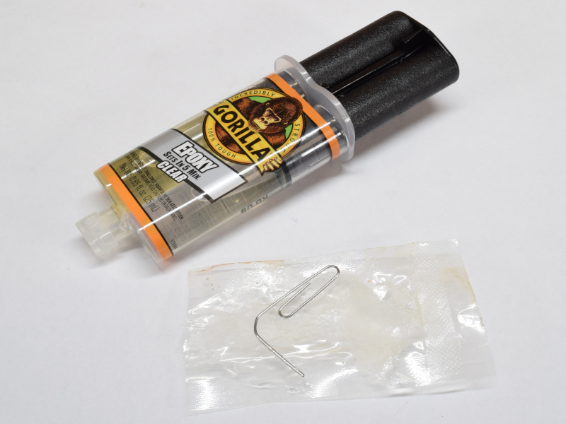 Mixing gorilla glue epoxy with a paperclip on a plastic sheet