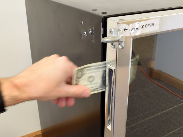 Sliding dollar bill between fridge door and frame