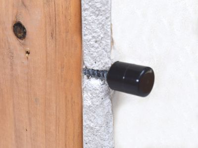 Cross section of a drywall with a magnet finding screw attached to stud