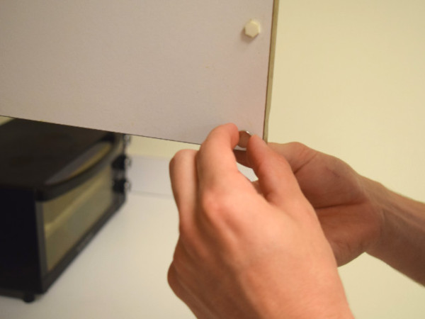 Sticking a magnet to cabinet door for a secure closure