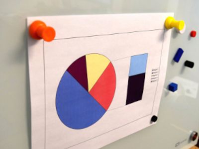 Magnet thumbtacks organizing documents on dry erase board