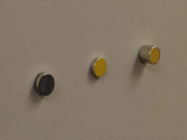 Magnets stuck on a metal wall